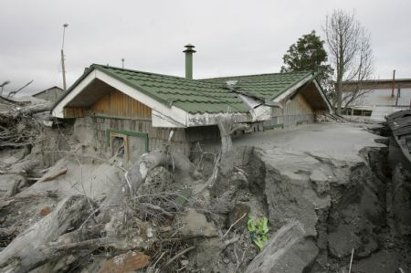 A house is buried in ashes after the eruption of Chaiten volcano near Chaiten town, located some 1,200 km south of Santiago, Chile, Feb. 26, 2009. The Chaiten volcano, which started erupting on Feb. 19, has buried the neighboring towns under a blanket of ashes. 