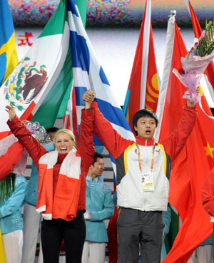Representatives of athletes (Front L) and volunteers (Front R) wave at the closing ceremony of the 24th Winter Universiade, Harbin, Northeast China's Heilongjiang Province, February 28, 2009. [Xinhua]