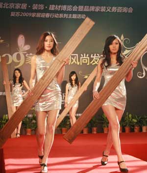 Some Chinese models display pieces of floor plank at a home decoration fair in Beijing, Feb. 28, 2009. 