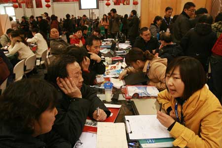 Chinese visitors talk with employees of an exhibiting company at a home decoration fair in Beijing, Feb. 28, 2009.