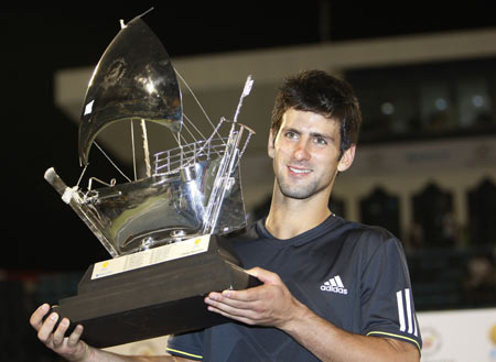 Novak Djokovic of Serbia holds up his trophy after winning his final match against David Ferrer of Spain at the ATP Dubai Tennis Championships, February 28, 2009.[Xinhua/Reuters]