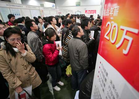 Job hunters look through job information on a job fair in Hangzhou International Exhibition Center, in Hangzhou city of east China's Zhejiang Province, Feb. 28, 2009. 