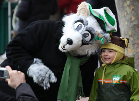 A performer with a wolf mask has a photo taken with a boy during the parade in Queens of New York, the United States, on March 1, 2009, prior to the Saint Patrick's Day. Saint Patrick's Day parades are now held throughout not only Ireland but also countries with big emigrant communities like the United States and Britain. The Saint Patrick's Day falls on March 17 annually.