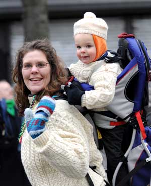 A woman carring a child on her back attends the parade in Queens of New York, the United States, on March 1, 2009, prior to the Saint Patrick's Day. Saint Patrick's Day parades are now held throughout not only Ireland but also countries with big emigrant communities like the United States and Britain. The Saint Patrick's Day falls on March 17 annually.