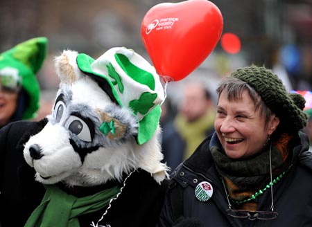 A performer with a wolf mask has a group photo taken with a woman during the parade in Queens of New York, the United States, on March 1, 2009, prior to the Saint Patrick's Day. Saint Patrick's Day parades are now held throughout not only Ireland but also countries with big emigrant communities like the United States and Britain. The Saint Patrick's Day falls on March 17 annually.