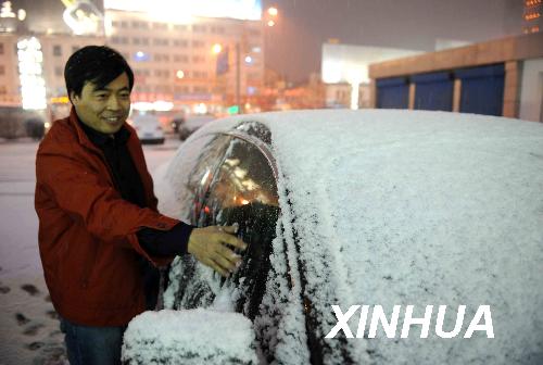 A citizen removes the snow from his car in Hohhot, the capital of the Inner Mongolian Autonomous Region, yesterday. Snow has hit parts of Central China and will continue in the coming days.