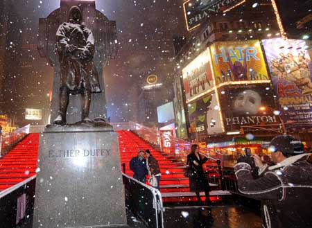 People take photographs in snow at Times Square in New York, the United States, on March 1, 2009. A historical heavy snow in March fell in New York on Sunday.