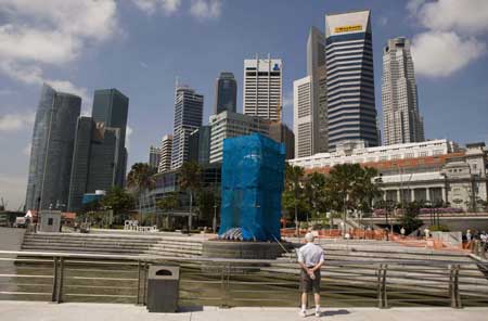 A tourist looks at the covered Merlion statue as it undergoes repair in Singapore March 2, 2009. Singapore's iconic Merlion statue, a popular tourist attraction, was damaged by lightning on Saturday afternoon during a thunderstorm, government radio reported. No one was hurt.