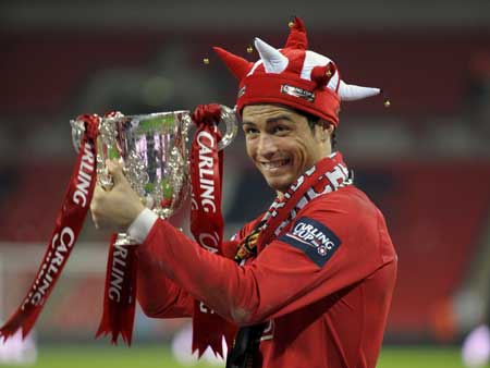 Manchester United's Cristiano Ronaldo smiles while holding the trophy after defeating Tottenham Hotspur in their English League Cup final soccer match at Wembley Stadium in London March 1, 2009.