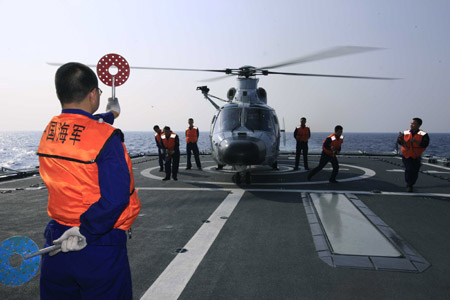 A Chinese soldier instructs the helicopter to take off from destroyer 'Guangzhou' in the Indian Ocean on the way to Pakistan March 2, 2009. 