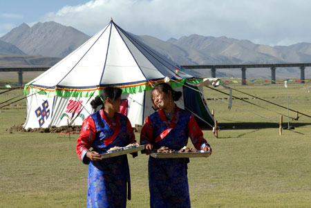 Two women prepare to welcome tourists in the north of southwest China's Tibet Autonomous Region June 25, 2007.
