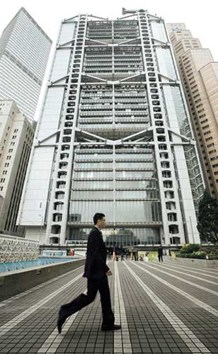A man walks past HSBC headquarters in Hong Kong. Billionaire Li Ka-shing, Hong Kong's richest man, and a group of fellow tycoons are underwriting about US$1.1 billion of HSBC Holdings Plc's stock sale. [Shanghai Daily]