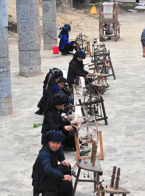 Elders of the Hani ethnic group show their traditional weaving machines during the 'China Honghe terrace culture tourism festival' in Yuanyang County, southwest China's Yunnan Province, March 1, 2009. [Chen Haining/Xinhua] 