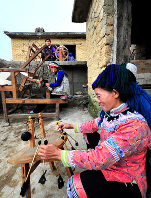 Women of the Hani ethnic group demonstrate the use of weaving machines during the 'China Honghe terrace culture tourism festival' in Yuanyang County, southwest China's Yunnan Province, March 1, 2009. [Chen Haining/Xinhua]