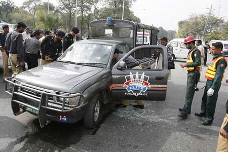 Pakistani policemen inspect a damaged police van at a shooting site in Lahore March 3, 2009. 