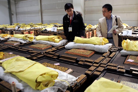 People check traditional Chinese musical instrument 'fou', or drum, at a pre-auction exhibition in Beijing, capital of China, March 3, 2009. About 1,000 'fou', which were used for performances at the opening ceremony of the 2008 Beijing Olympics, are to be auctioned as the Olympic legacy in Beijing from March 8. [Xinhua]