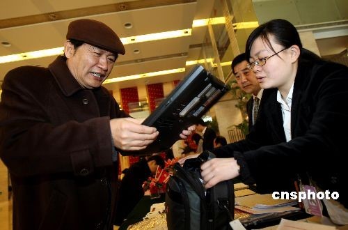A member of the Chinese People's Political Consultative Conference (CPPCC) checks in at the secretariat of the annual session in Beijing on March 2. The organizing committee provides each CPPCC member with a laptop to inquire about information of the conference.