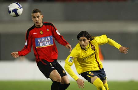Barcelona's Martin Caceres (R) and Mallorca's Mario Suarez challenge for the ball during their Spanish King's Cup semi-final second leg soccer match at Ono stadium in Palma de Mallorca March 4, 2009. [Xinhua/Reuters]