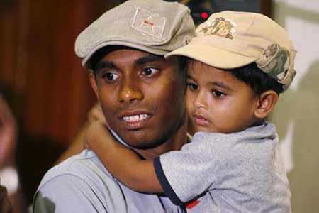 Thilan Thushara, a member of the Sri Lankan cricket team, holds his son as he arrives at Colombo airport in Sri Lanka, after the attack against his team yesterday morning in Pakistan March 4, 2009. 