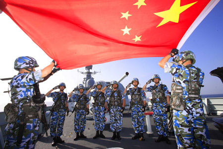 Chinese marine special force corps pose for a photo with Chinese national flag on board of destroyer 'Guangzhou' in the Indian Ocean on the way to Pakistan March 4, 2009. A Chinese naval task force including destroyer 'Guangzhou' and a helicopter will attend the 'Peace-09' exercise in the seas off Pakistan. 