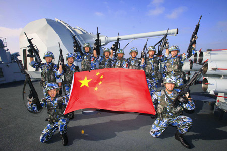 Chinese marine special force corps pose for a photo with Chinese national flag on board of destroyer 'Guangzhou' in the Indian Ocean on the way to Pakistan March 4, 2009. A Chinese naval task force including destroyer 'Guangzhou' and a helicopter will attend the 'Peace-09' exercise in the seas off Pakistan. 