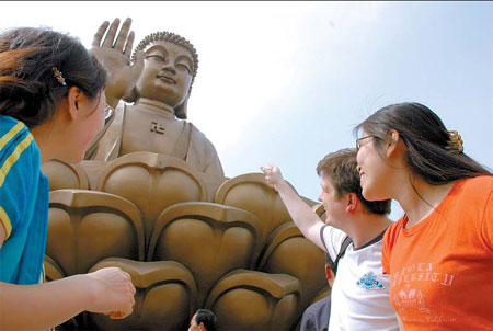 Three tourists look at the world's largest bronze Buddha in Longkou, Shandong province. 