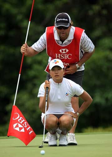 Seon Hwa Lee of South Korea lines up a putt with her caddie John Wilkes on the fifth green. [Scott Halleran/Getty Images] 