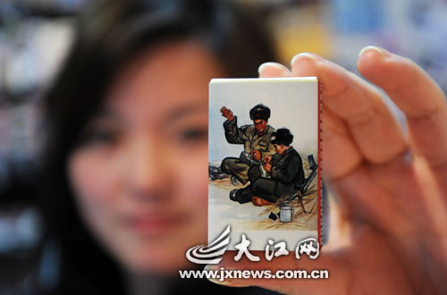 A girl shows a matchbox emblazoned with Lei Feng's image, in a store in Nanchang, Jiangxi province on March 4, 2009. [Photo: jxnews.com.cn]