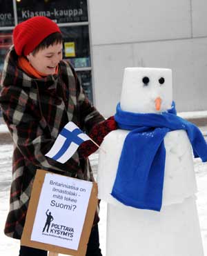 An environmental protection activist decorates the snowman during a protest against the warming up climate in Helsinki, capital of Finland, March 4, 2009. [Zhao Changchun/Xinhua]