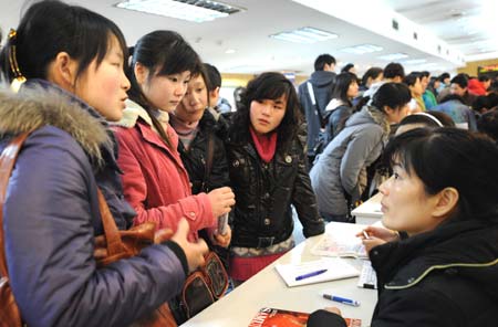 Job seekers (L) talk to an employee during a job fair in Nanjing, capital of east China's Jiangsu Province, March 5, 2009. The job fair was organized by local branch of the All-China Women's Federation and only accepted female job seekers as a measure to help more women get employed.