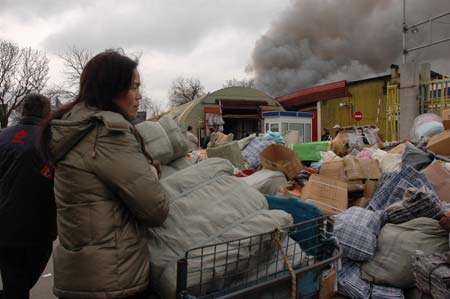 A Chinese shop owner stands outside a market where there are many Chinese shop owners in Sofia, capital of Bulgaria, on March 5, 2009. A fire broke out in a shopping section where there are more than 20 Chinese stalls on early Thursday. The fire is still burning and no casualties were reported so far. 