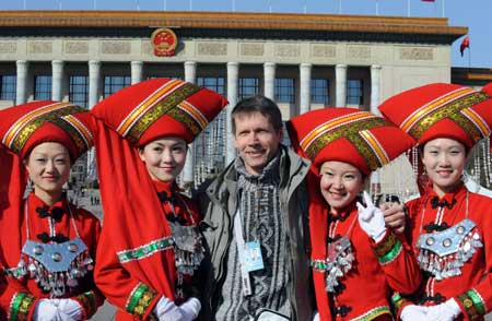 Attendants take photos with a foreigner outside the Great Hall of the People in Beijing, capital of China, March 5, 2009. The Second Session of the 11th National People's Congress (NPC) opened on Thursday. 