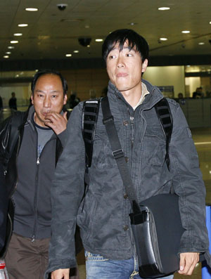 Chinese 110m hurdle star Liu Xiang (R) arrives in Shanghai, east China, March 8, 2009. Liu came back to Shanghai on Sunday after a successful foot surgery and three-month rehabilitation in the United States. [Xinhua]