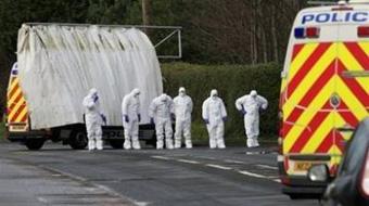 Forensic officers search for evidence outside the entrance to the Massereene army base in County Antrim. [Peter Muhly/CCTV/AFP] 