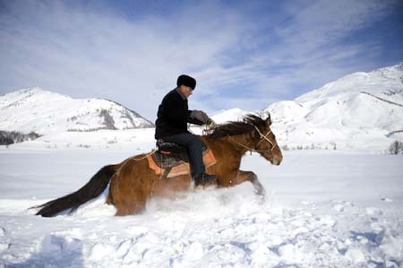 A herdsman rides a horse in the snow in the Kanasi scenic area, northwest China&apos;s Xinjiang Uygur autonomous region, March 6, 2009. [Xinhua] 