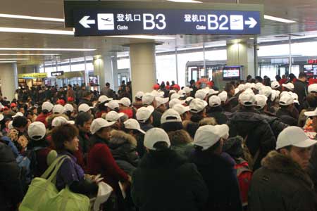 Passengers wait at the Shuangliu International Airport in Chengdu, capital of southwest China's Sichuan Province, March 9, 2009. A heavy fog hit the airport on Monday morning. The airport was forced to shut down for hours and nearly 10,000 passengers were delayed. 