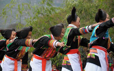 A bevy of young girls dance to a featuring show at the ongoing Cultural and Art Festival of King Bamboo of the Yelang State, a traditional folk festival among indigenous ethnic Miao people who claim themselves as offspring of the ancient King of the Yelang State dated back to over 2,000 years, at Zhenning County, southwest China's Guizhou Province, March 8, 2009.