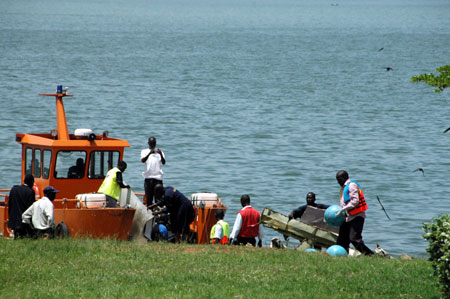 Rescuers carry the wreckage of a crashed cargo plane at Entebbe, 40km south of Kampala, on March 9, 2009. An Illyushin 76 cargo aircraft crashed in Lake Victoria, about 10 km south of Uganda's Entebbe international airport. 11 people aboard were feared dead in the Monday morning tragedy. Salvage efforts are underway. (Xinhua/Ronald Ssekandi)