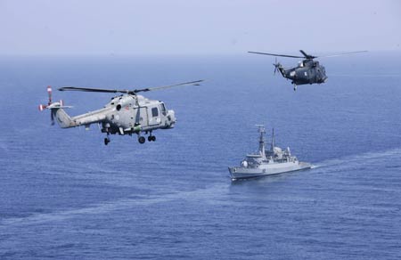 A warship and military helicopters attend the AMAN 09 military exercises at the Arabia Sea off the southern Pakistani port of Karachi, on Mar. 9, 2009. Warships from participating countries Monday began their second phase of the two-week-long AMAN 09 military exercises at the Arabia Sea off the southern Pakistani port of Karachi. (Xinhua/Zha Chunming)