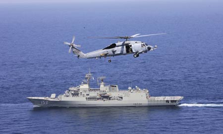 A warship and a military helicopter attend the AMAN 09 military exercises at the Arabia Sea off the southern Pakistani port of Karachi, on Mar. 9, 2009. Warships from participating countries Monday began their second phase of the two-week-long AMAN 09 military exercises at the Arabia Sea off the southern Pakistani port of Karachi. (Xinhua/Zha Chunming)