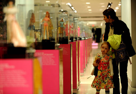 A woman and her daughter look at the Barbie dolls displayed during an exhibition at a shopping center in New York, the United States, on March 9, 2009. The exhibition held here displayed 120 Barbie dolls of 6 series to celebrate Barbie's 50th birthday. (Xinhua/Shen Hong)