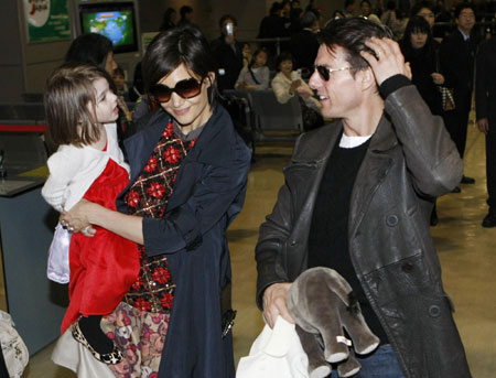 Actor Tom Cruise (R) speaks with his daughter Suri (L), who is held by her mother Katie Holmes, upon their arrival at Narita international airport in Narita March 8, 2009. Tom and his family flew in to Japan on Sunday to promote his movie 'Valkyrie'.