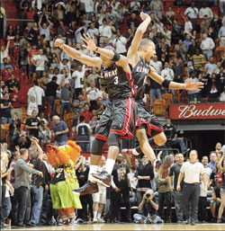 Miami Heat's Dwyane Wade (left) celebrates teammate Jamario Moon's basket in the first overtime of their NBA game against the Chicago Bulls on Monday. [Shanghai Daily]