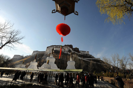 Tibetan pilgrims turn the pray wheels near the Potala Palace during the Grand Summons Ceremony in Lhasa, southwest China's Tibet Autonomous Region, on March 10, 2009. (Xinhua/Gaesang Dawa)