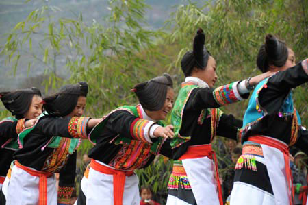 A bevy of young girls dance to a featuring show at the ongoing Cultural and Art Festival of King Bamboo of the Yelang State, a traditional folk festival among indigenous ethnic Miao people who claim themselves as offspring of the ancient King of the Yelang State dated back to over 2,000 years, at Zhenning County, southwest China&apos;s Guizhou Province, March 8, 2009. [Photo: Xinhua] 
