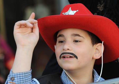 A boy dressed as a cowboy watches the annual Purim Festival Parade in Holon, south of Tel Aviv, March 10, 2009. Jewish people celebrated their Purim Festival from March 10 to 11 this year. (Xinhua/Yin Bogu)