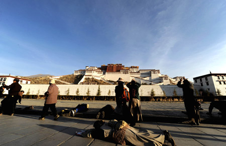 Tibetan pilgrims turn the pray wheels in front of the Potala Palace during the Grand Summons Ceremony in Lhasa, southwest China's Tibet Autonomous Region, on March 10, 2009.