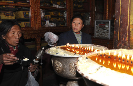Tibetan pilgrims add butter into Buddha lamps at the Sera Monastery during the Grand Summons Ceremony in the suburb of Lhasa, southwest China's Tibet Autonomous Region, on March 10, 2009. 