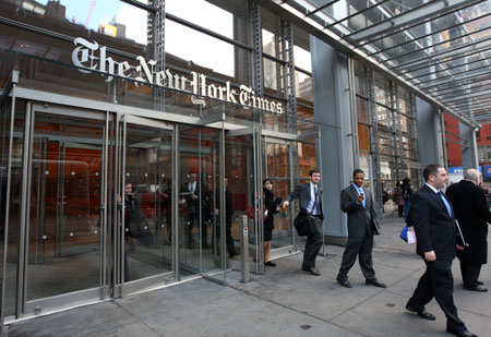 Employees walk out of the headquarters building of New York Times in Manhattan of New York, March 10, 2009. 