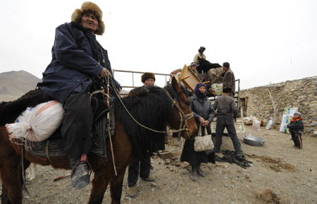 Kazak herder Elbek watches the leaving flock of lambs on his way to spring pasture in the Kazak Autonomous Prefecture of Ili, northwest China's Xinjiang Uygur Autonomous Region, March 7, 2009. 